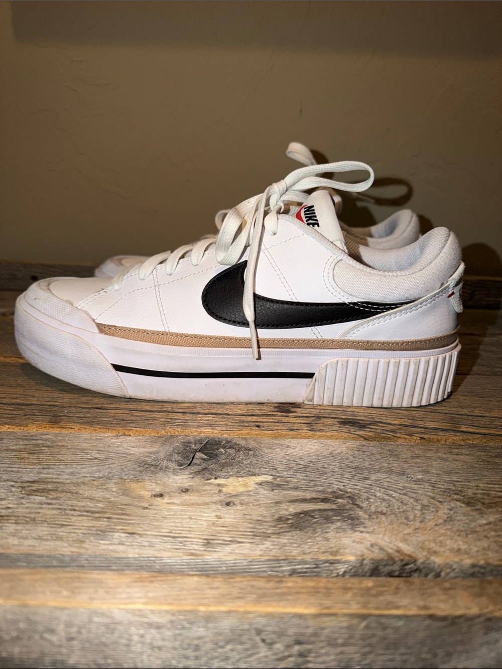 Nike White Low-Top Sneakers with Black Swoosh and Gold Stripe